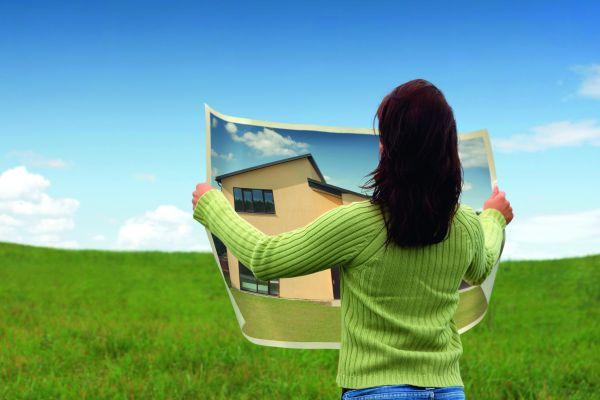 женщина с фотографией дома в руках